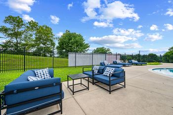 A blue sofa and a black coffee table are on a patio.
